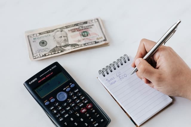 stick to budget with pen and paper and calculator